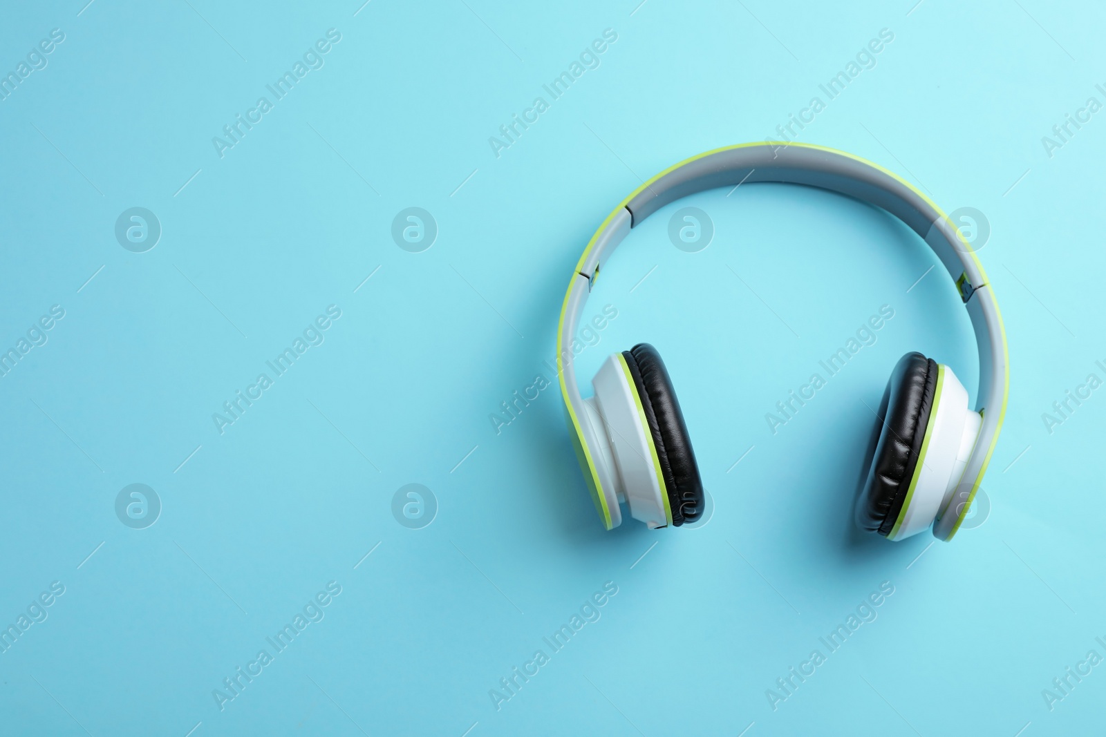 Photo of Wireless headphones on color background, top view. Space for text