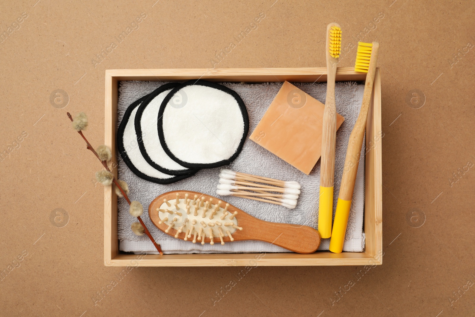 Photo of Wooden box with eco friendly products on craft paper, top view