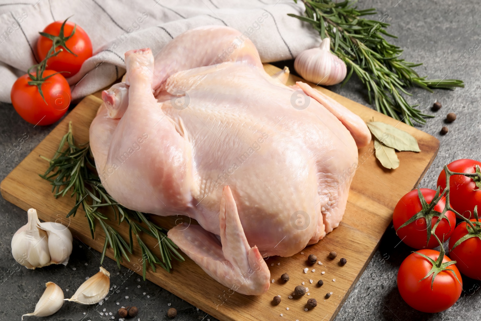 Photo of Fresh raw chicken with spices and vegetables on grey table