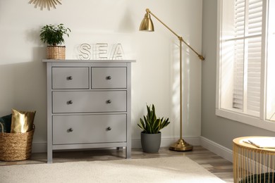 Photo of Grey chest of drawers in stylish room interior