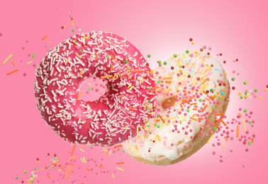 Image of Sweet delicious donuts falling on pink background