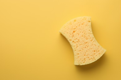 Photo of Sponge on yellow background, top view. Space for text