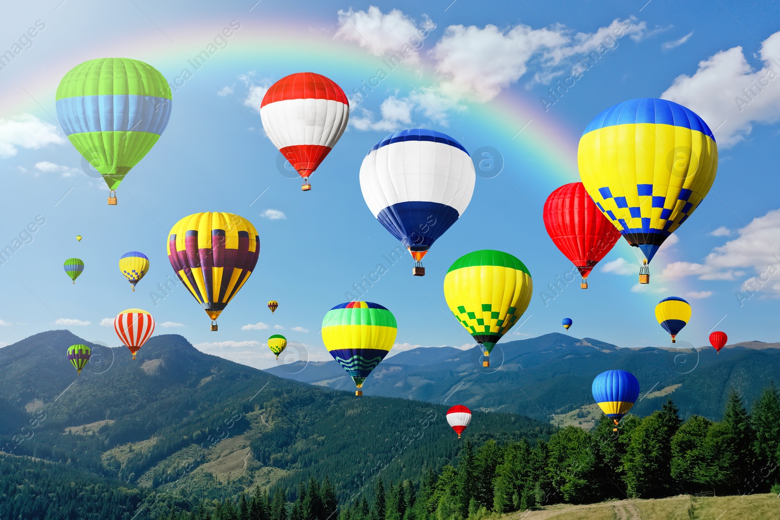 Image of Bright hot air balloons flying over mountains