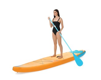 Happy woman with paddle on orange SUP board against white background