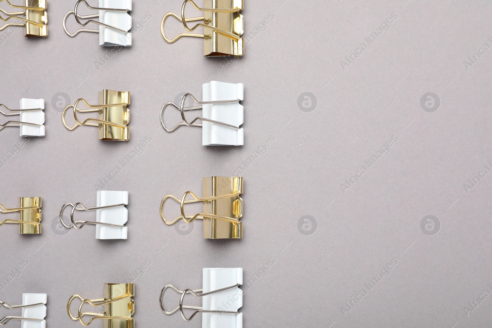 Photo of Binder clips on grey background, flat lay. Space for text