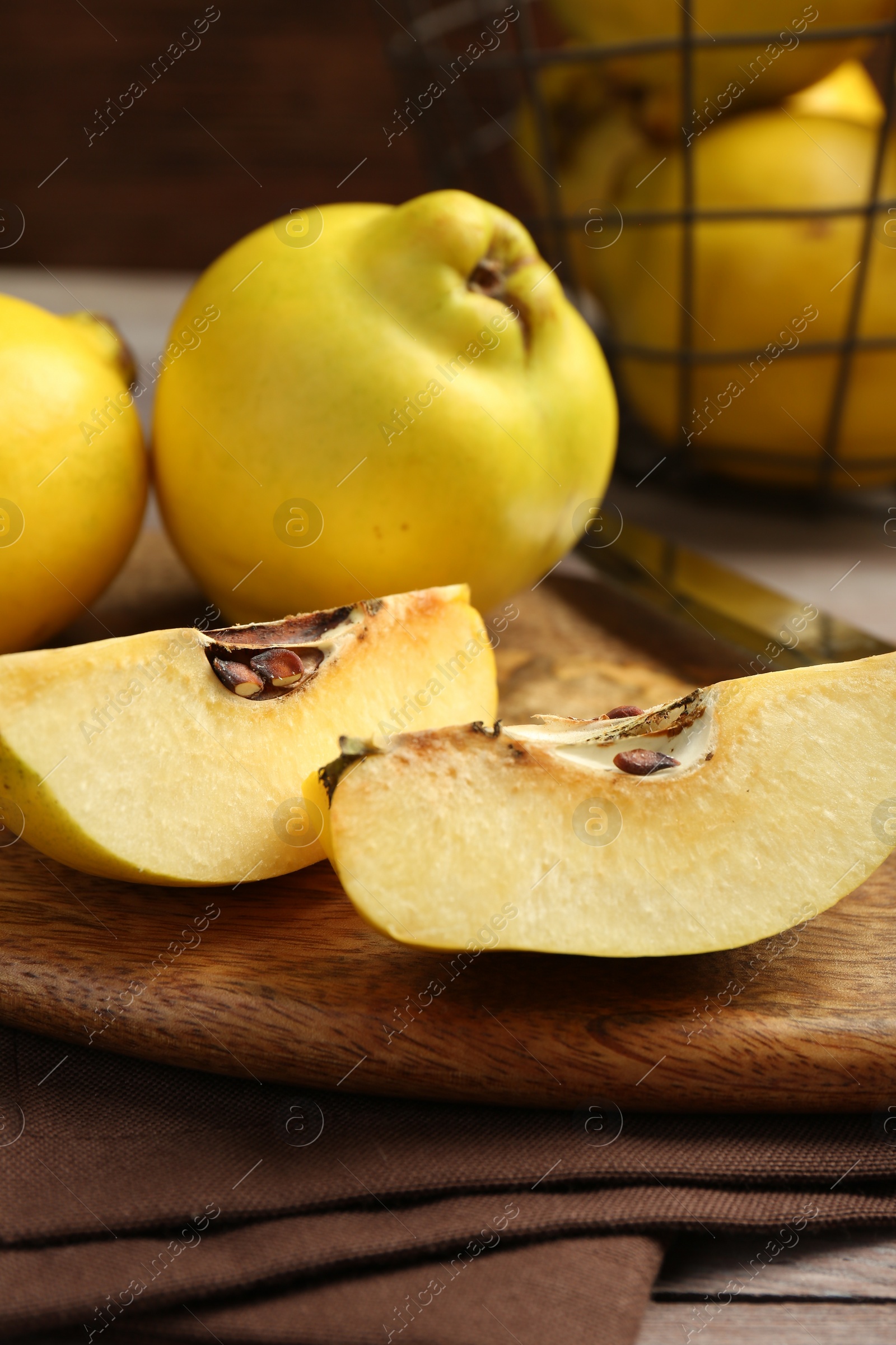 Photo of Ripe whole and cut quinces on table, closeup