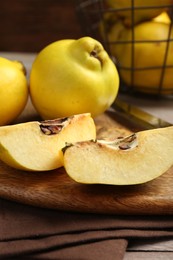 Photo of Ripe whole and cut quinces on table, closeup