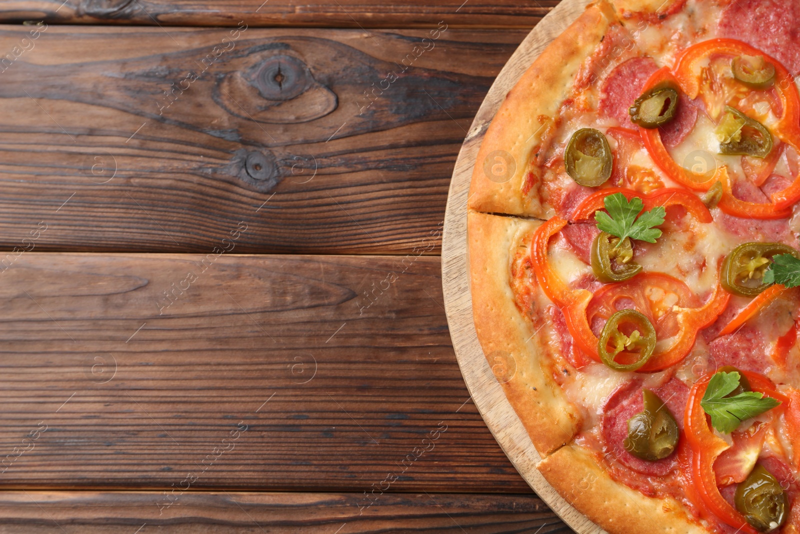 Photo of Delicious pizza Diablo on wooden table, top view. Space for text