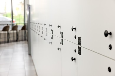 Photo of Rows of white lockers in modern hostel
