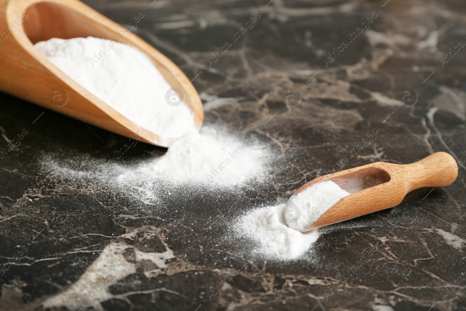 Photo of Scoops with baking soda on dark table