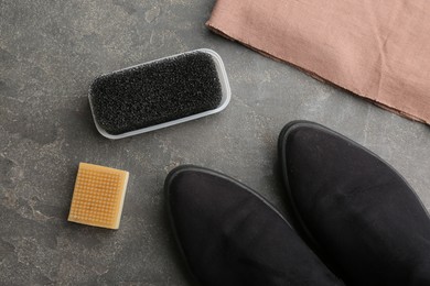 Photo of Stylish footwear with shoe care accessories on grey stone table, flat lay