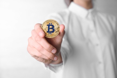 Photo of Young woman holding bitcoin on white background, closeup