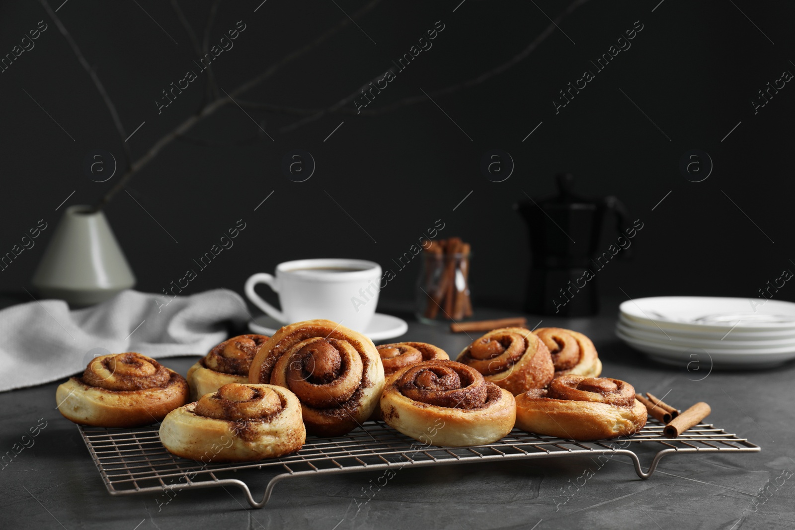 Photo of Tasty cinnamon rolls on black table, space for text