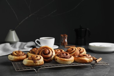 Tasty cinnamon rolls on black table, space for text