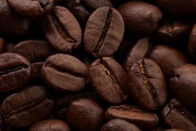 Photo of Aromatic roasted coffee beans as background, closeup