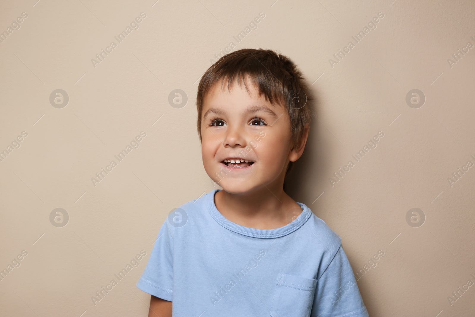 Photo of Portrait of cute little boy on beige background