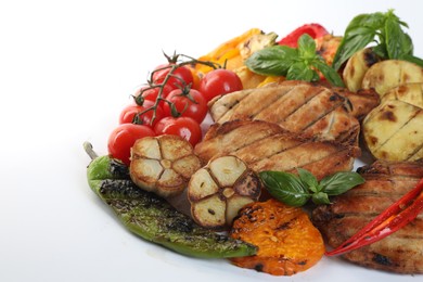 Photo of Tasty grilled vegetables, meat, fresh cherry tomatoes and basil isolated on white