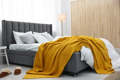 Bright plaid on bed in stylish bedroom