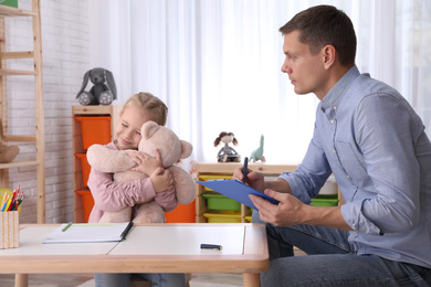 Child psychotherapist working with little girl in office