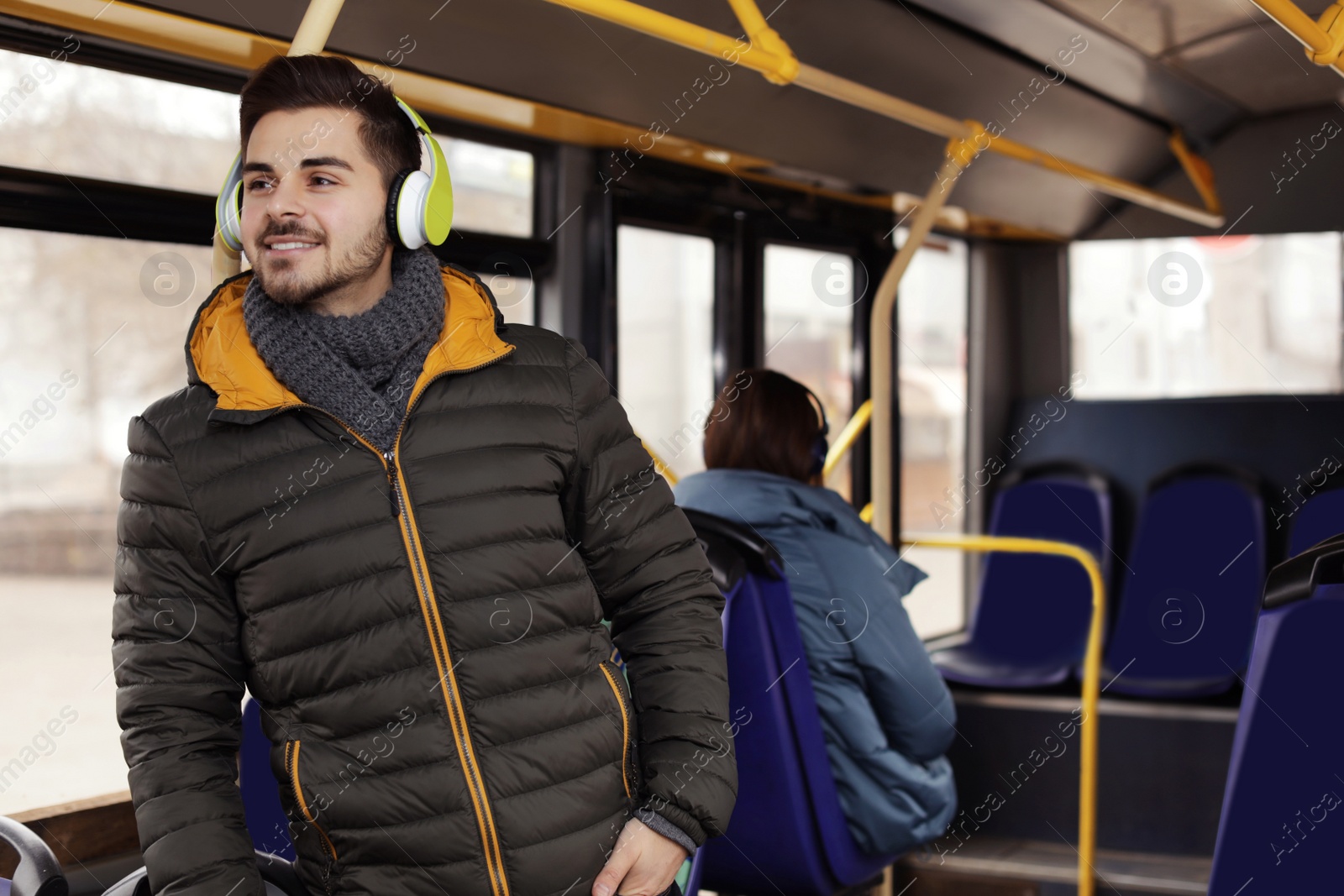 Photo of Young man listening to music with headphones in public transport