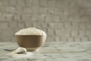 Ceramic bowl with flour on white marble table, space for text. Cooking utensil