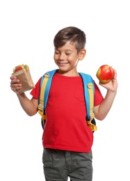 Schoolboy with healthy food and backpack on white background