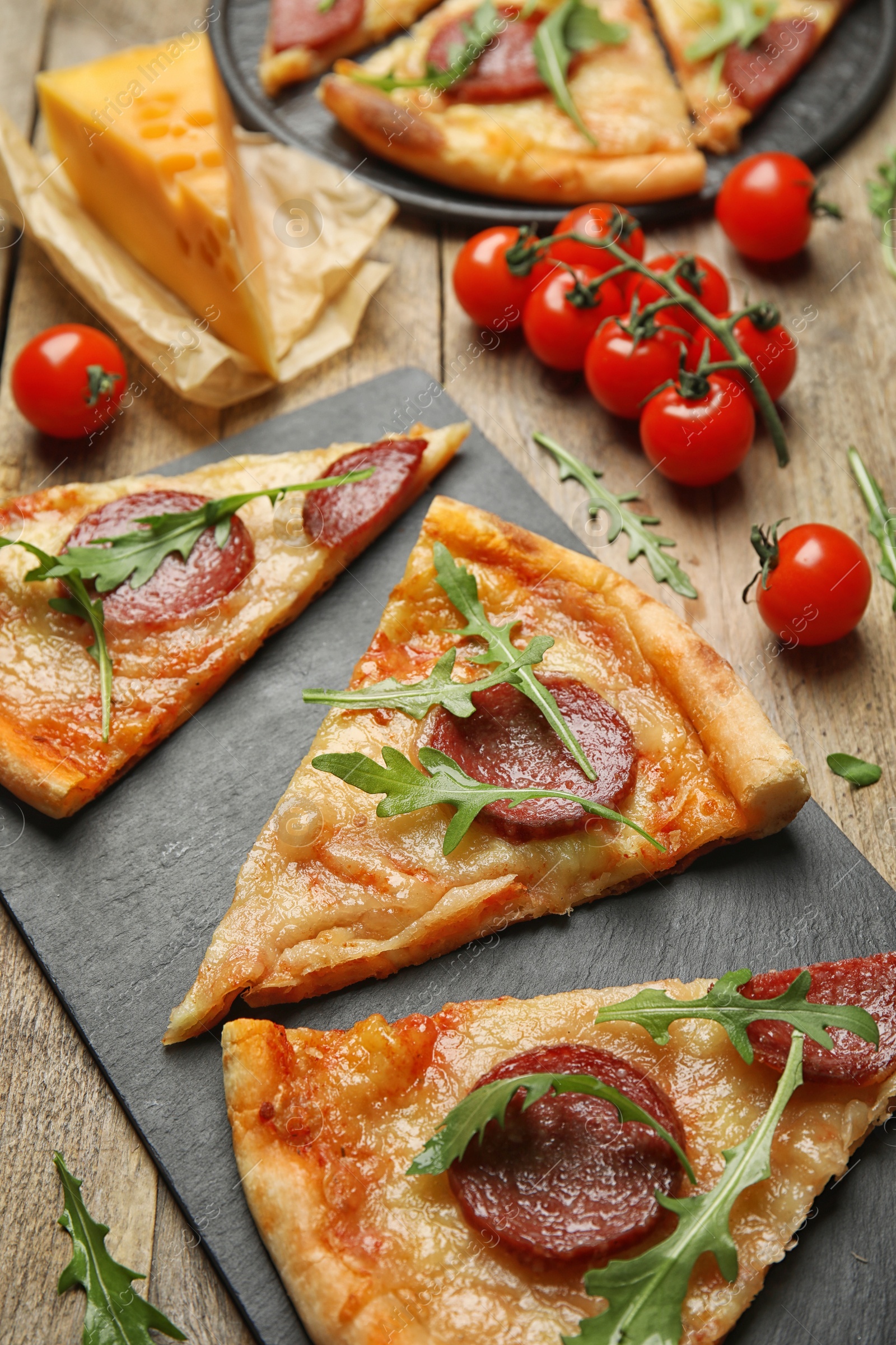 Photo of Tasty pepperoni pizza with arugula on wooden table