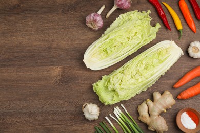 Flat lay composition with fresh Chinese cabbages and ingredients on wooden table. Space for text