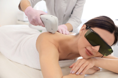 Young woman undergoing laser epilation procedure in beauty salon