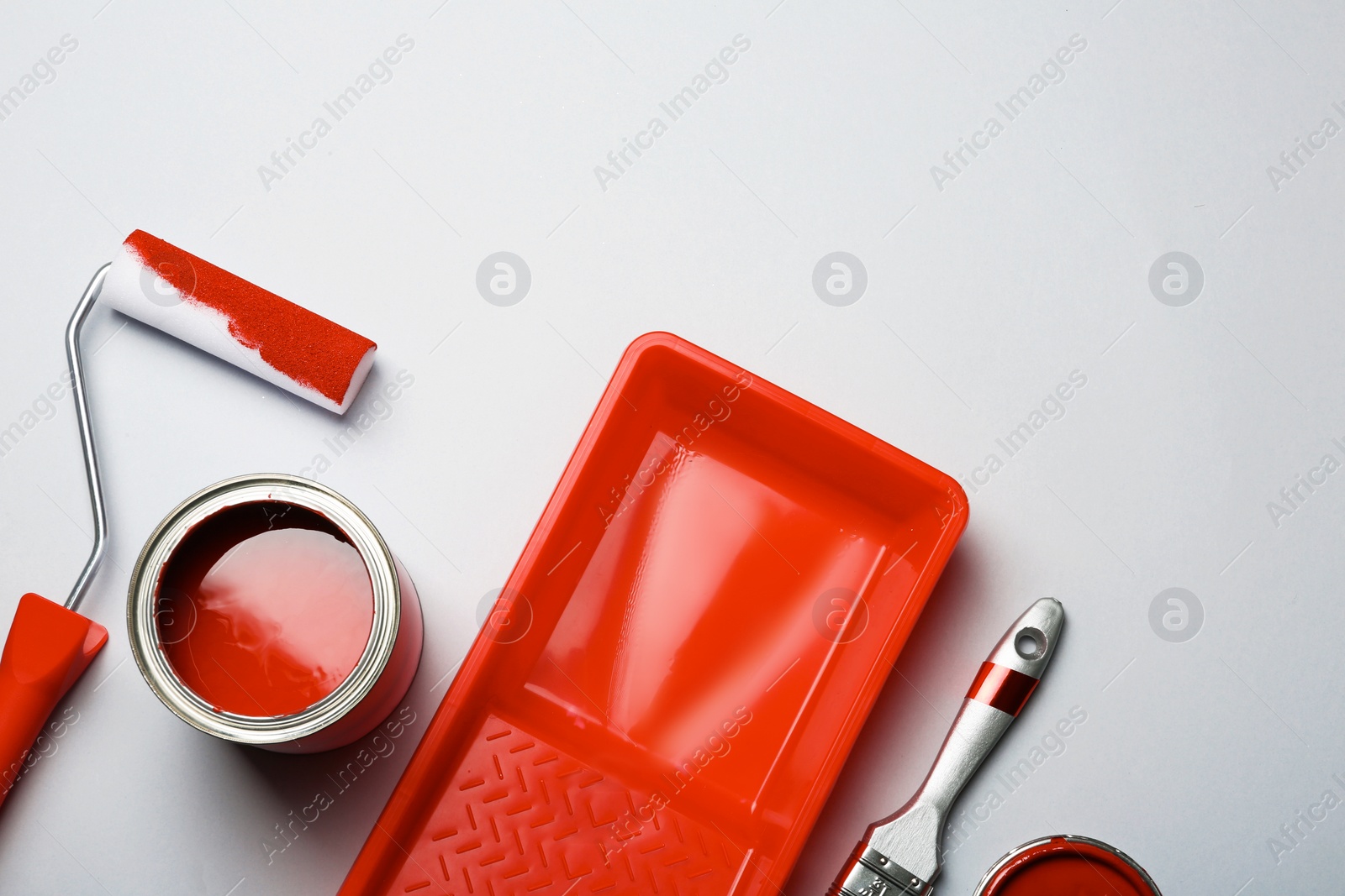 Photo of Flat lay composition with paint can, decorator tools and space for text on color background