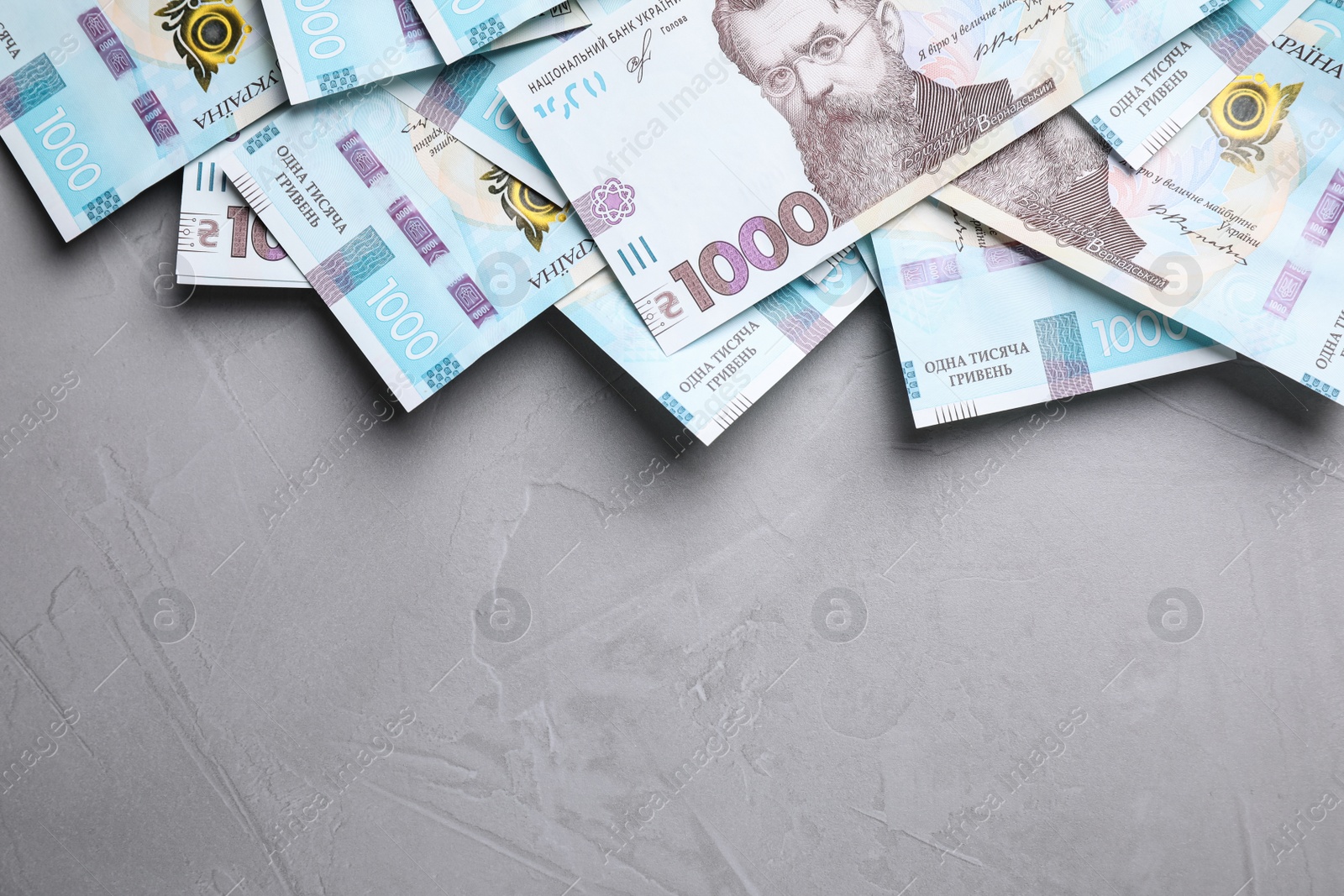 Photo of Ukrainian money on grey background, flat lay. Space for text