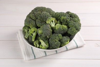 Bowl of fresh raw broccoli on white wooden table