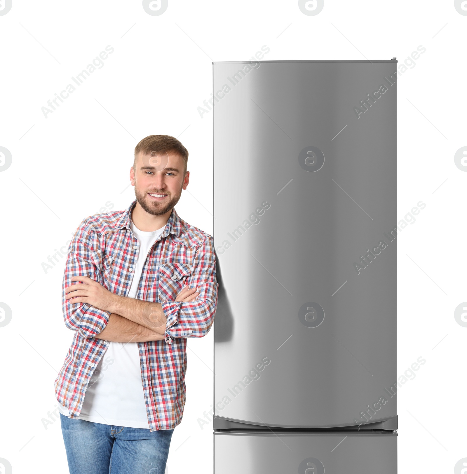 Photo of Young man near closed refrigerator on white background