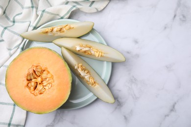 Photo of Tasty colorful ripe melons on white marble table, top view. Space for text