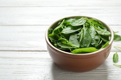 Fresh green healthy spinach on white wooden table. Space for text