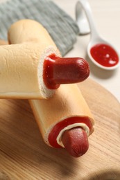 Tasty french hot dogs and dip sauce on wooden board, closeup