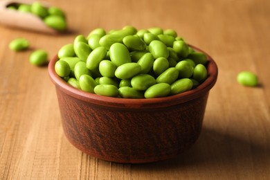 Photo of Bowl of delicious edamame beans on wooden table