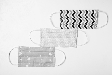 Homemade protective masks on white background, flat lay. Sewing idea