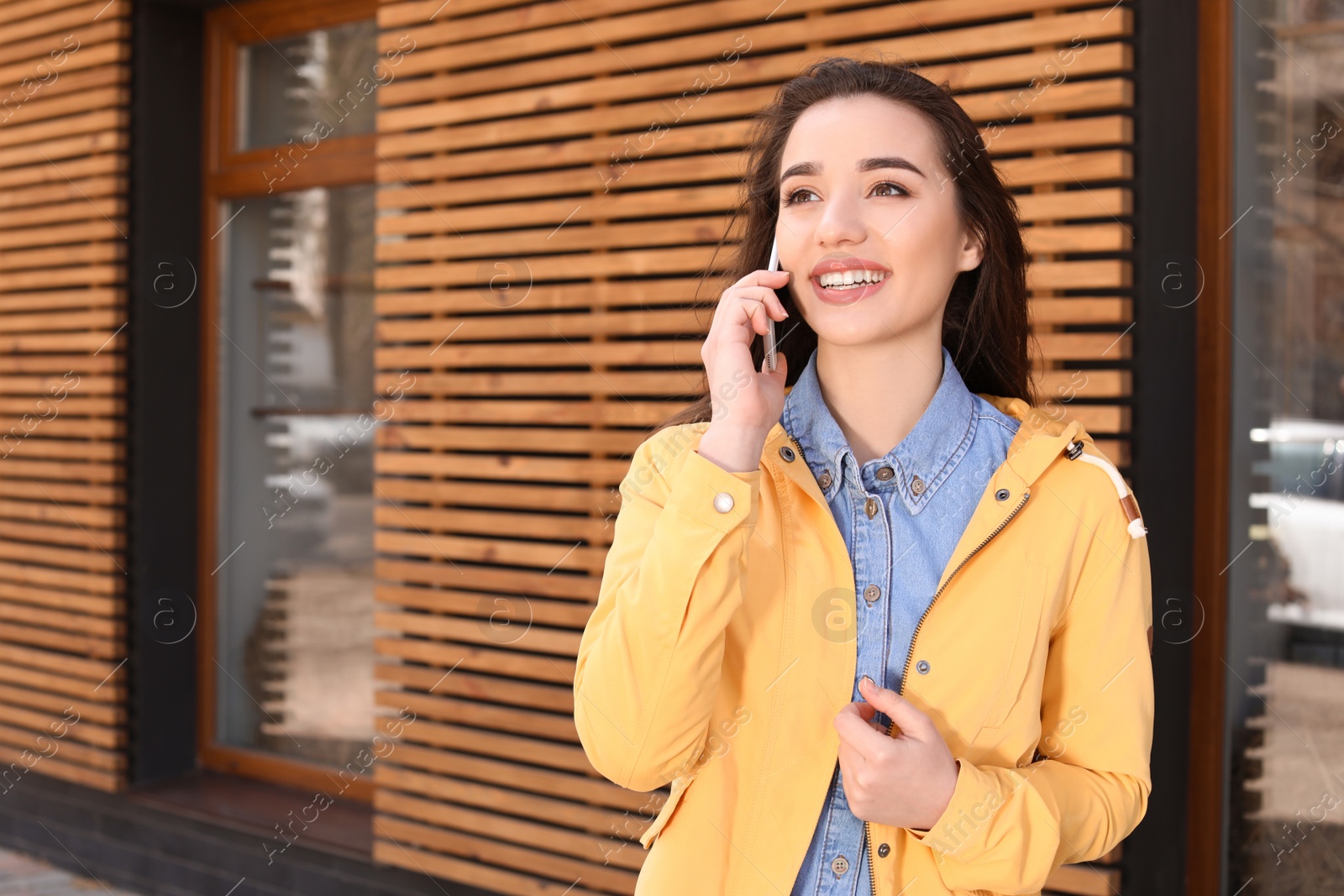 Photo of Beautiful young woman talking on phone outdoors