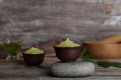 Bowl of hemp lotion on wooden table