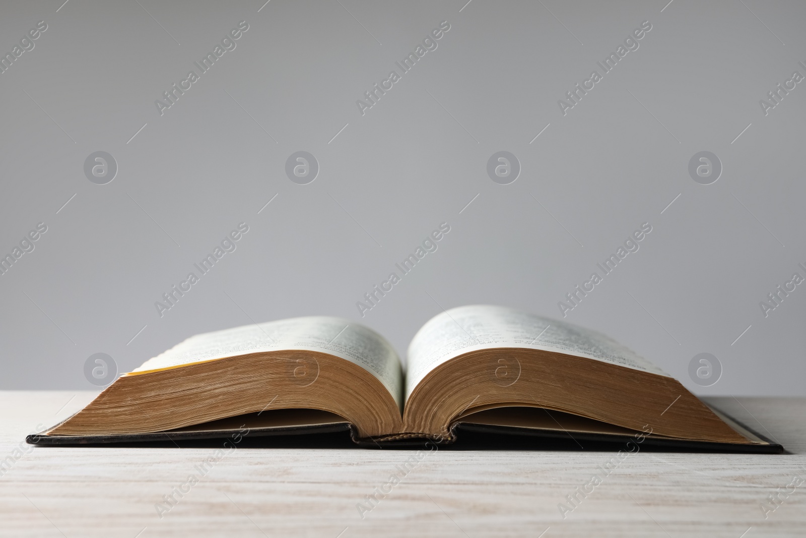 Photo of Open Bible on wooden table. Christian religious book