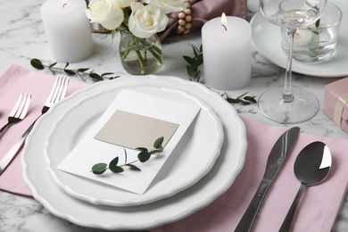 Elegant festive table setting with blank card on white marble background