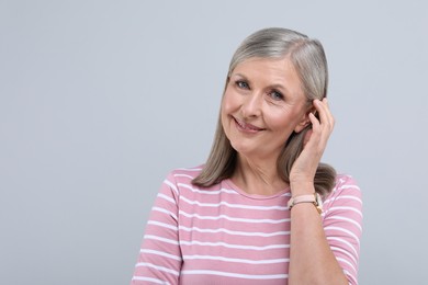 Photo of Portrait of beautiful senior woman on light grey background. Space for text