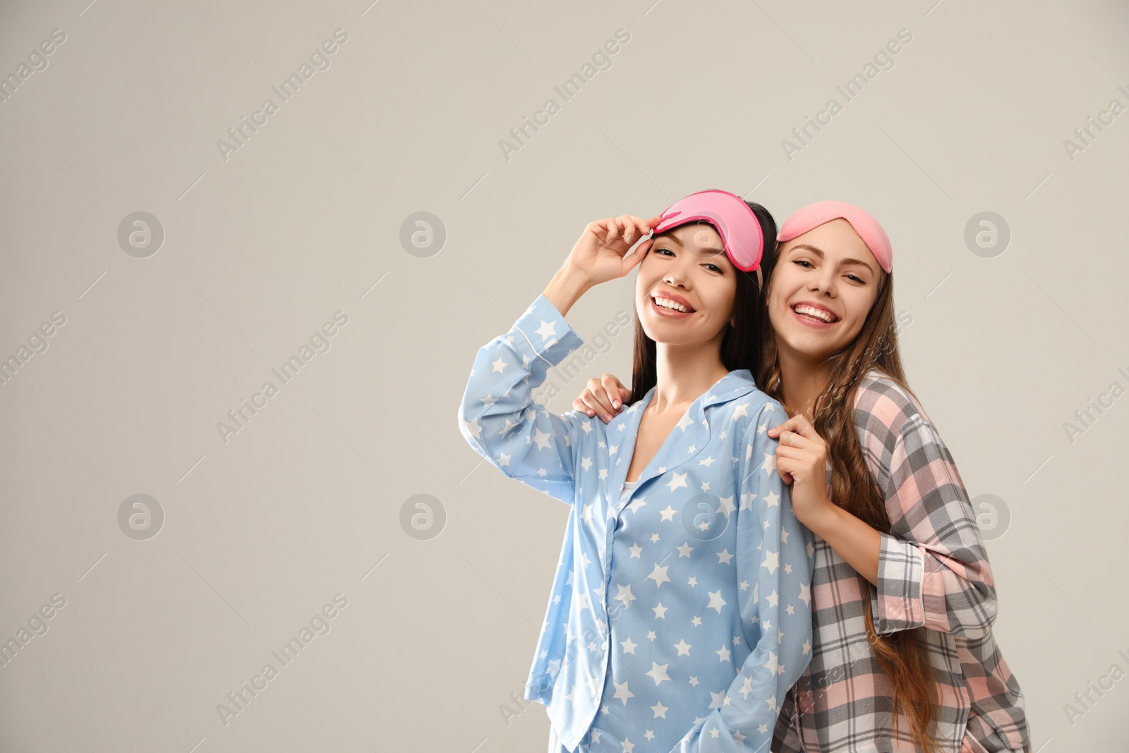 Photo of Beautiful women in pajamas on beige background, space for text. Bedtime