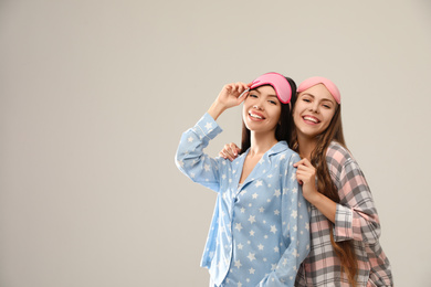 Photo of Beautiful women in pajamas on beige background, space for text. Bedtime