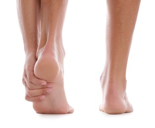 Photo of Back view of man suffering from foot pain on white background, closeup