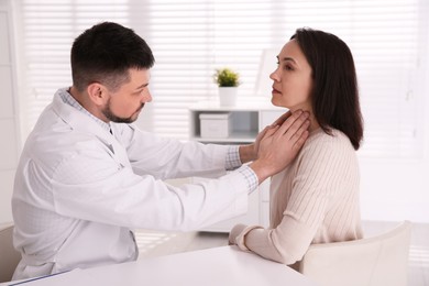 Photo of Doctor examining thyroid gland of patient in hospital