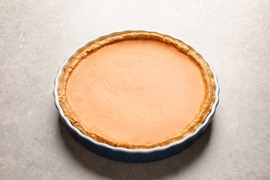 Photo of Fresh delicious homemade pumpkin pie on gray background