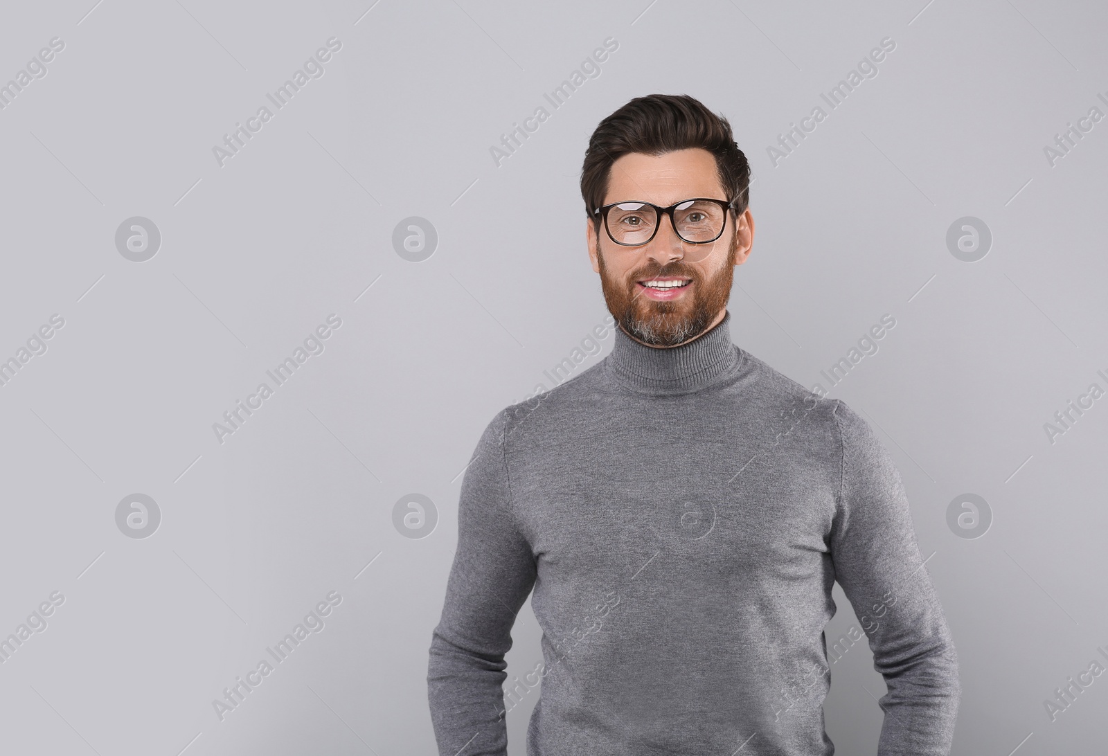 Photo of Portrait of handsome man in glasses on light grey background, space for text