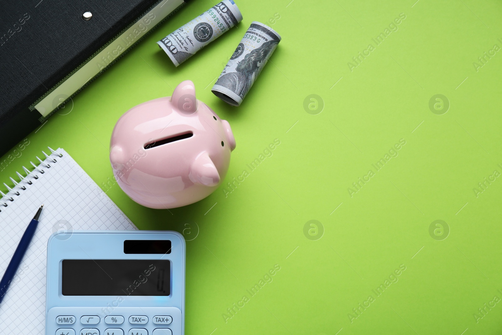 Photo of Piggy bank, notebook, calculator and banknotes on light green background, flat lay. Space for text